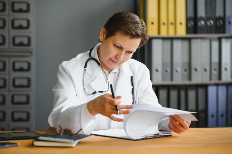 portrait-of-middle-aged-female-doctor-sitting-at-desk_creating-psychiatric-treatment-plan